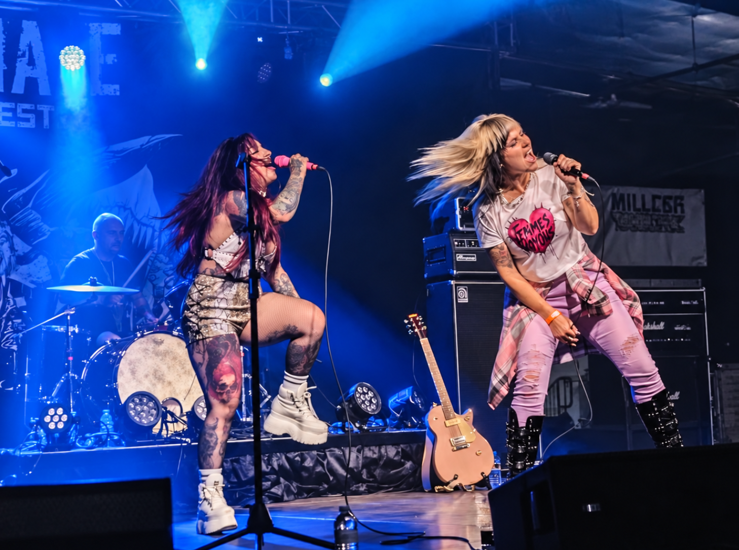 Femmes Voyous performing together under blue stage lights